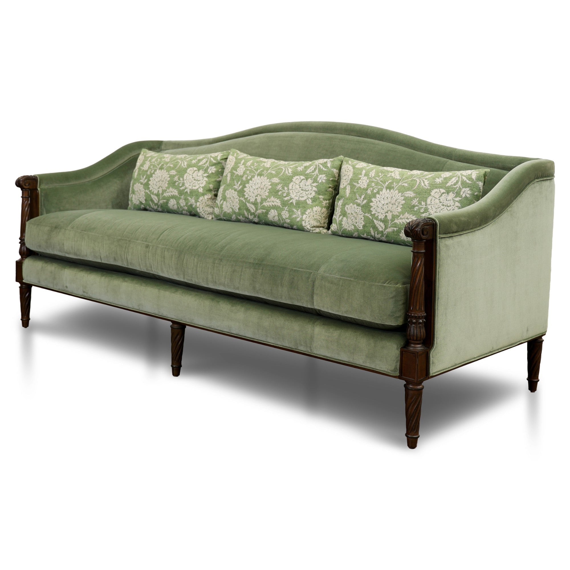 Green sofa with floral-patterned cushions on a white background